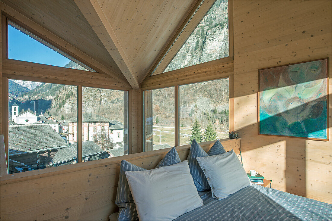 Wood-paneled bedroom with panoramic view of the mountain landscape