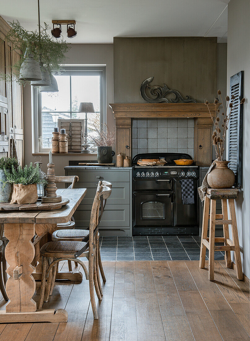 Landhausküche mit Esstisch aus Holz und antikem Herd