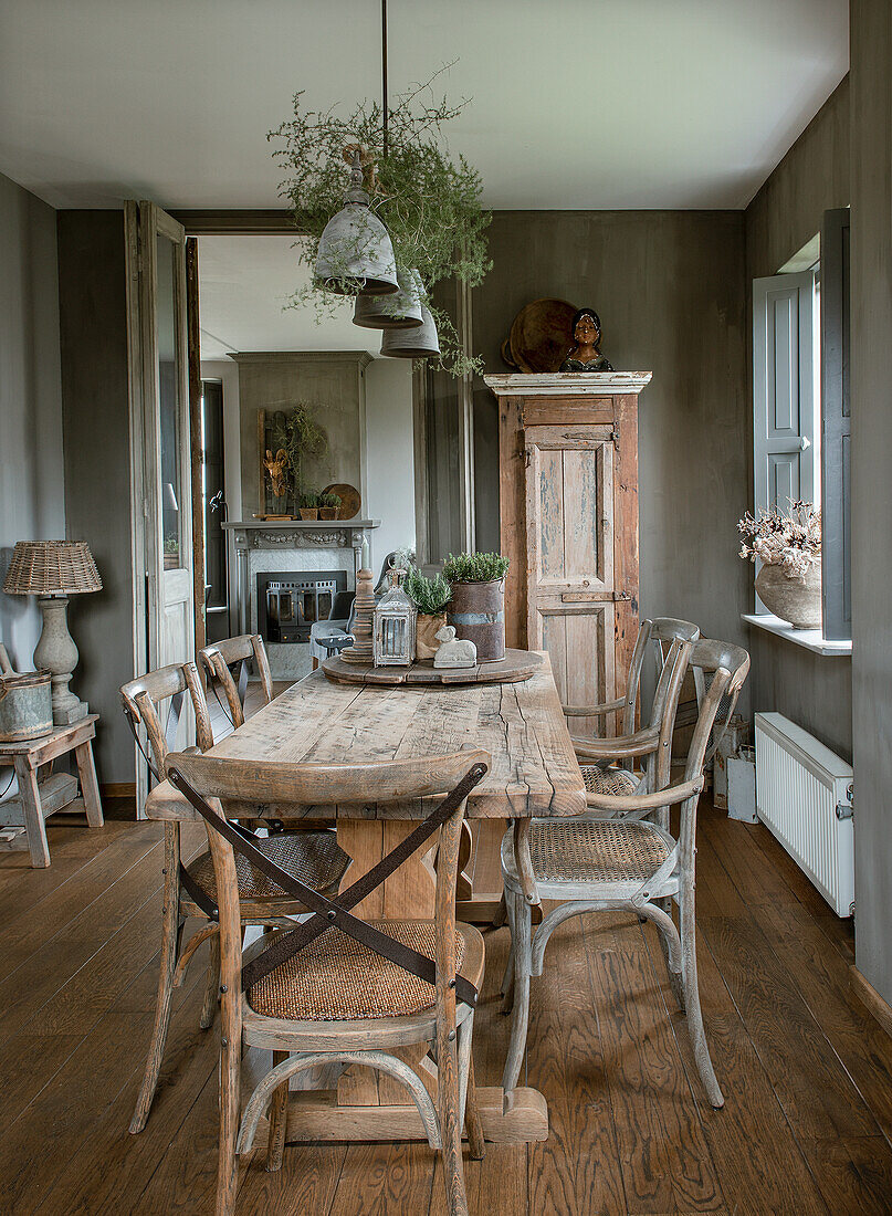 Esszimmer mit rustikalem Holztisch, Holzstühlen und antikem Schrank