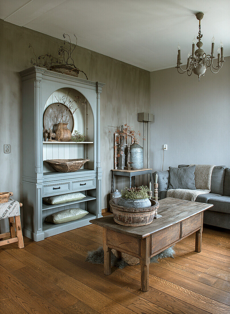 Living room with grey cabinet, wooden table and chandelier