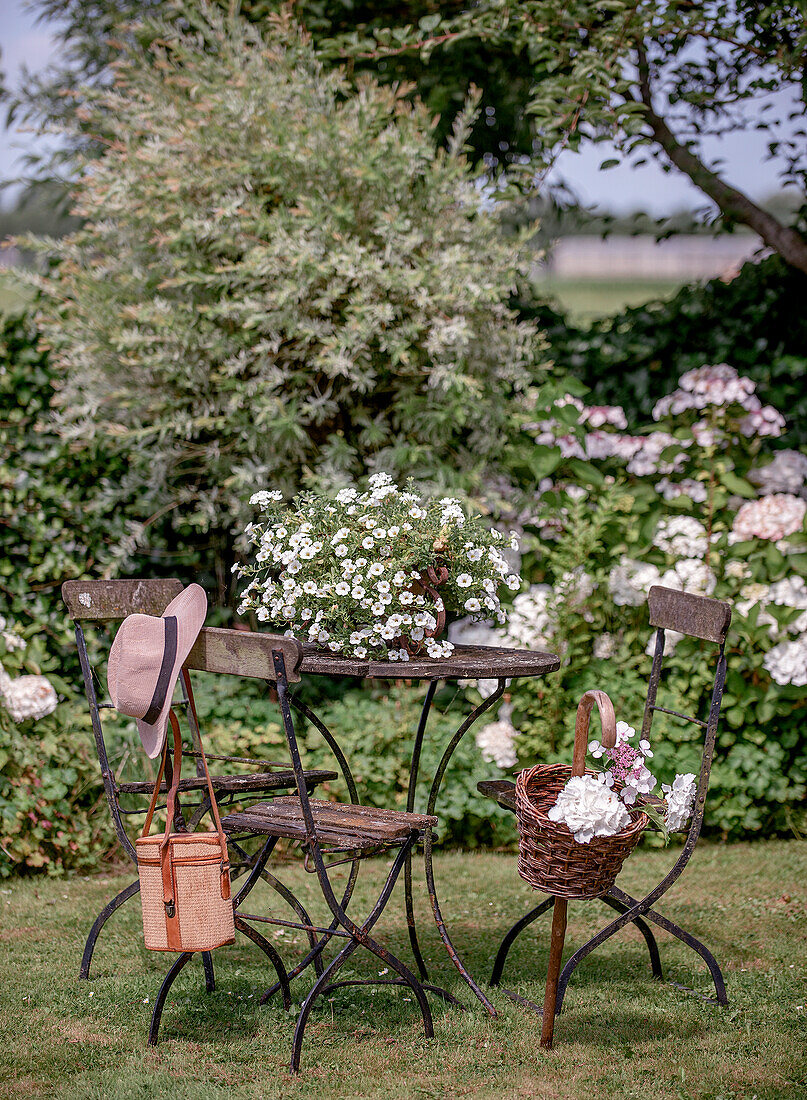 Gemütliche Sitzgelegenheit mit Metalltisch und -stühlen im Garten