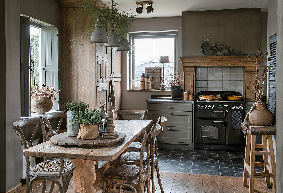 Rustic kitchen with wooden table, chairs and antique oven