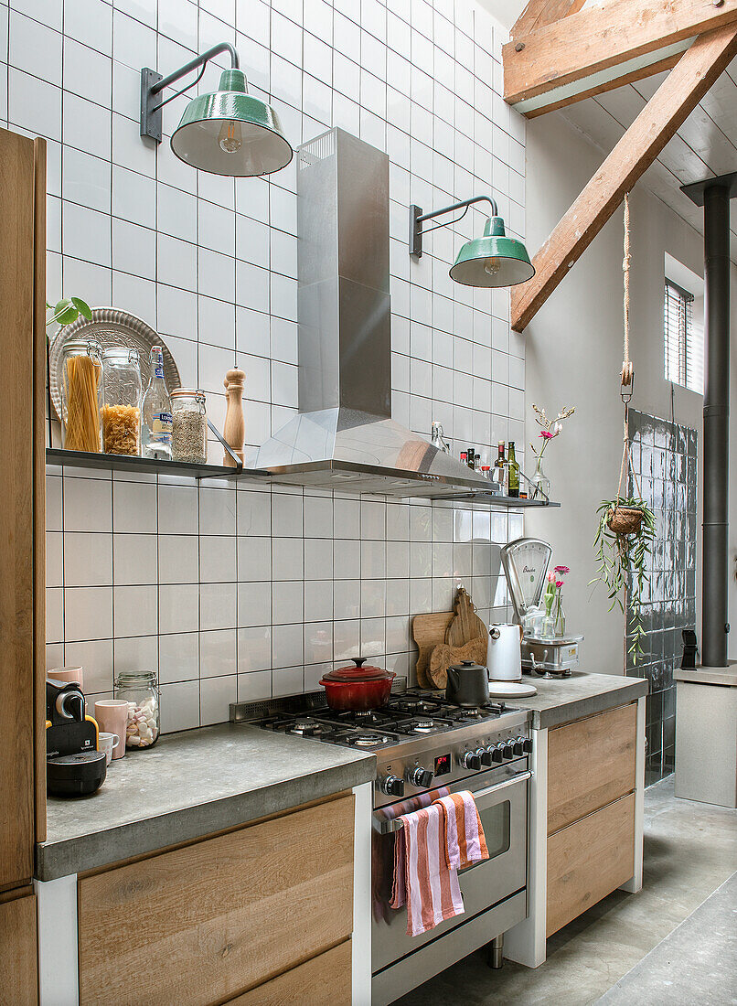 Modern kitchen with wooden cabinets, tiled backsplash and stainless steel extractor hood