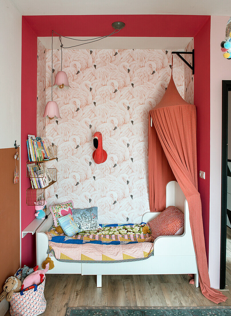 Children's room with flamingo wallpaper and canopy over the alcove bed