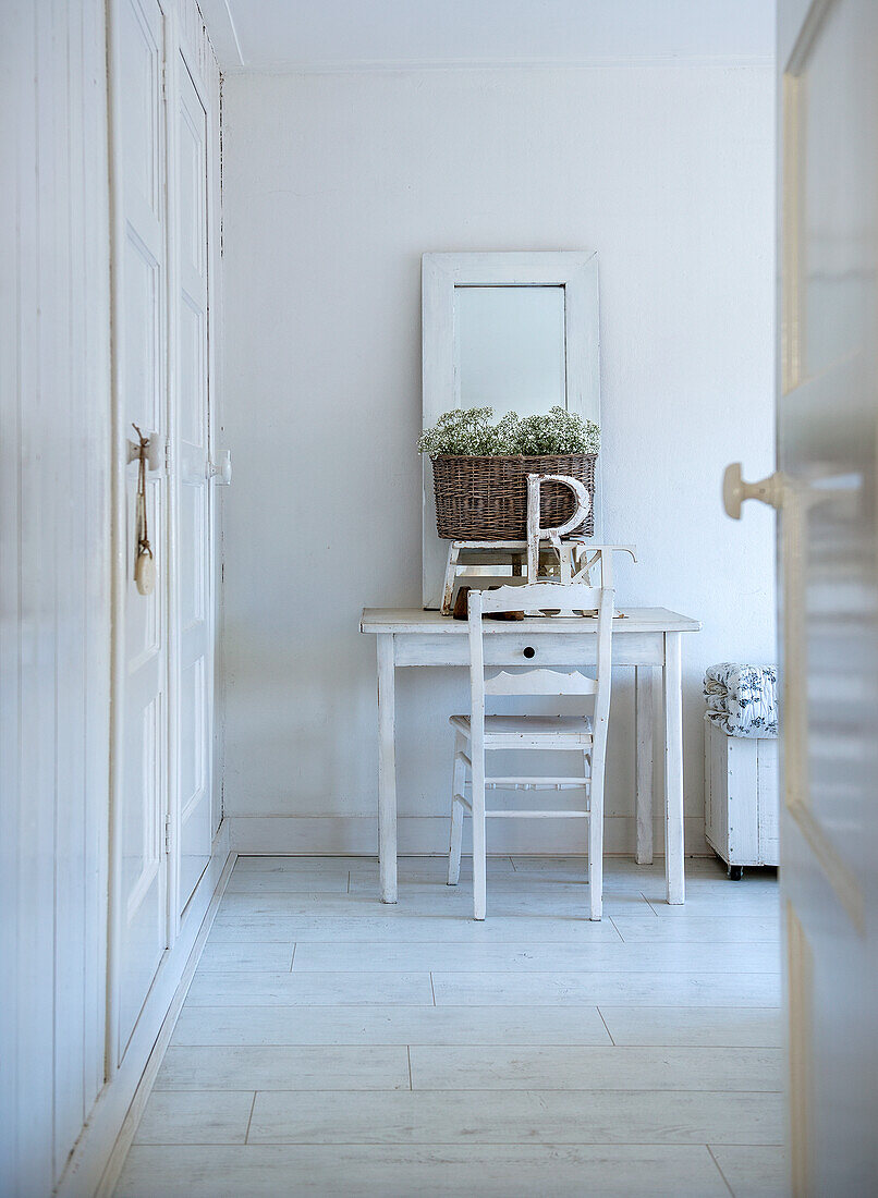 Dressing table with chair and mirror in white hallway