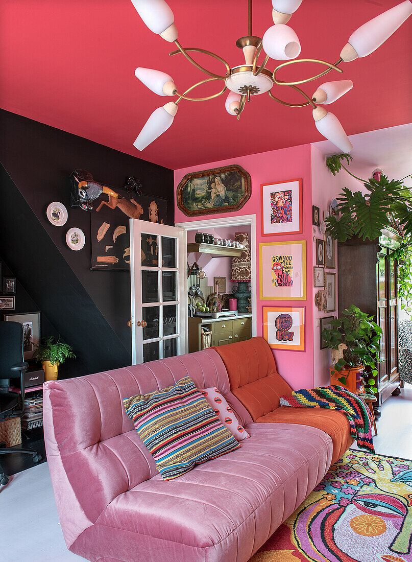 Living room with pink ceiling, colorful wall decorations and pink couch