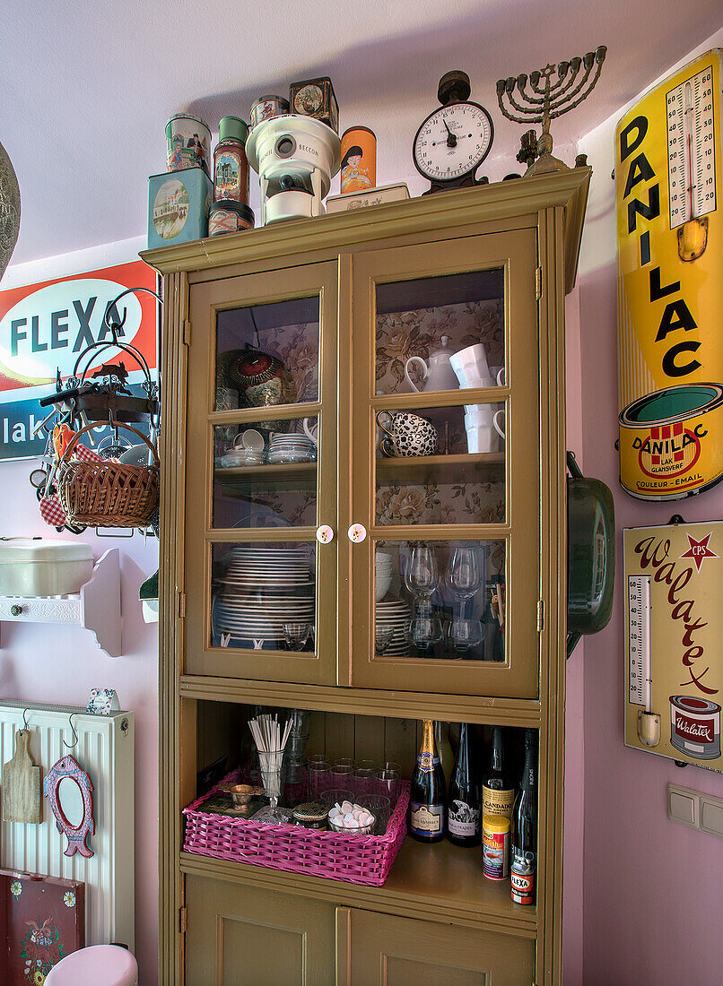 Vintage kitchen cabinet with crockery and spirits, surrounded by retro decorative elements