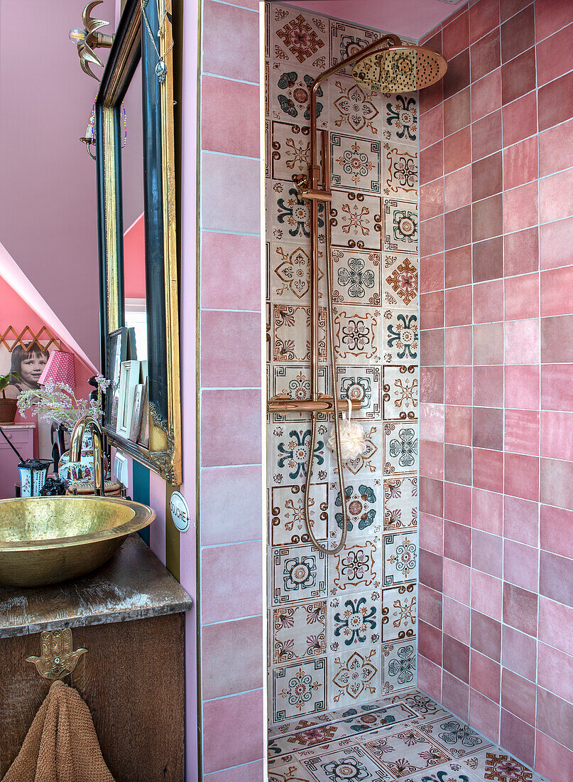 Dusche mit Mosaikfliesen und goldener Regendusche in rosa gekacheltem Badezimmer