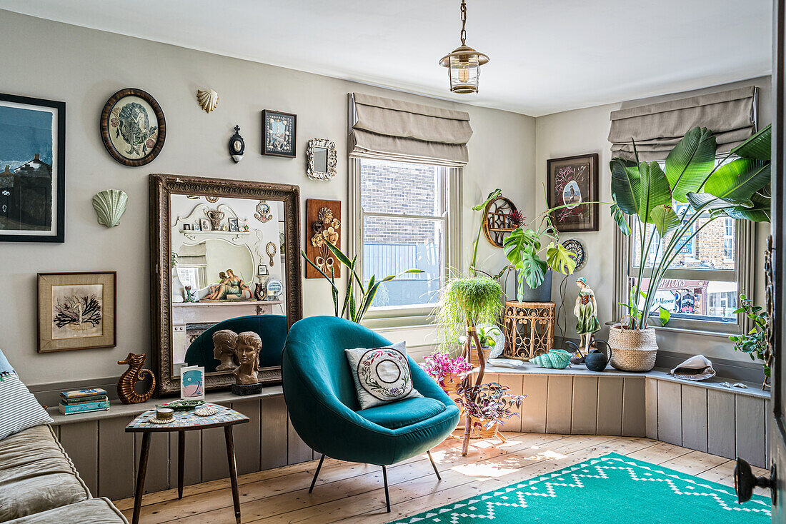 Cosy living room with retro armchair, lots of plants and decorative mirror