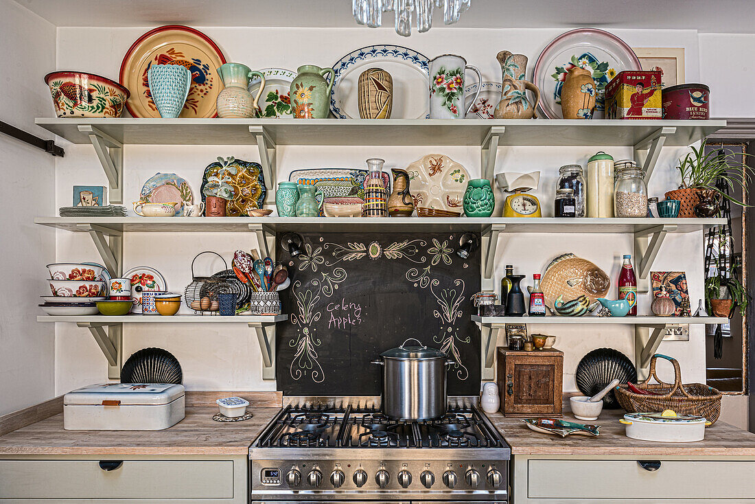 Shelves with colourful ceramic crockery and decoration in a rustic kitchen