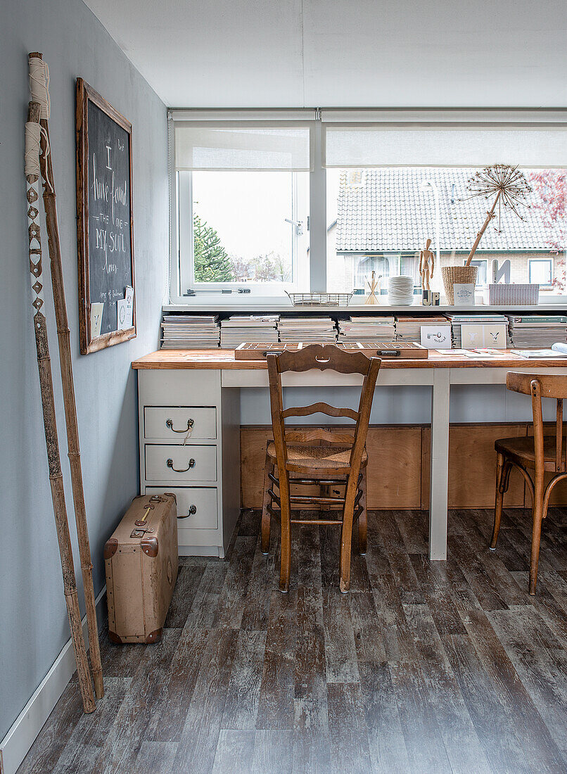 Desk with wooden chairs and chalkboard in the study