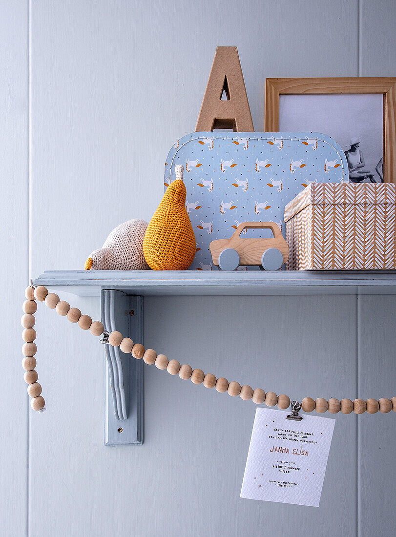 Nursery shelf with wooden toys, decorations and crocheted fruit