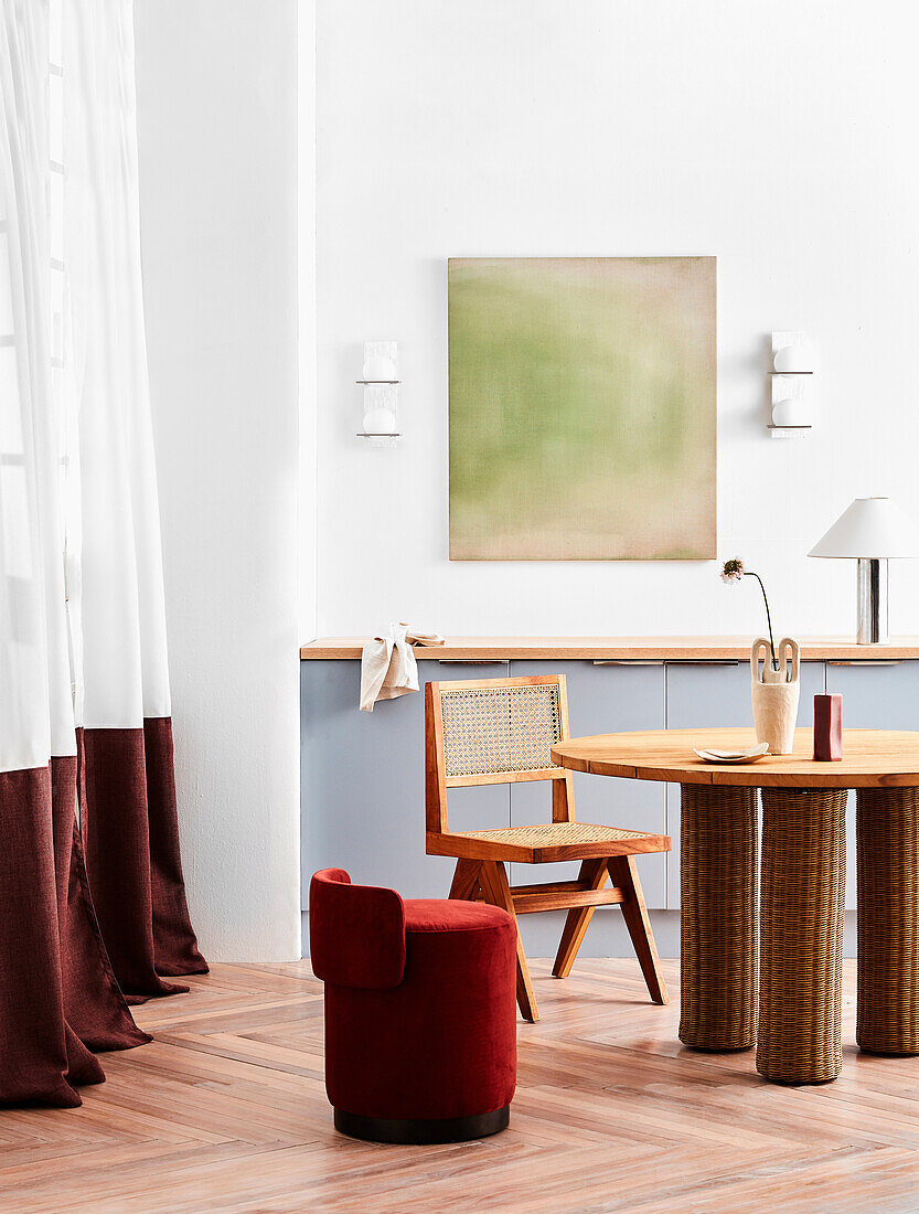 Workplace with rattan table, chair and red upholstered stool chair