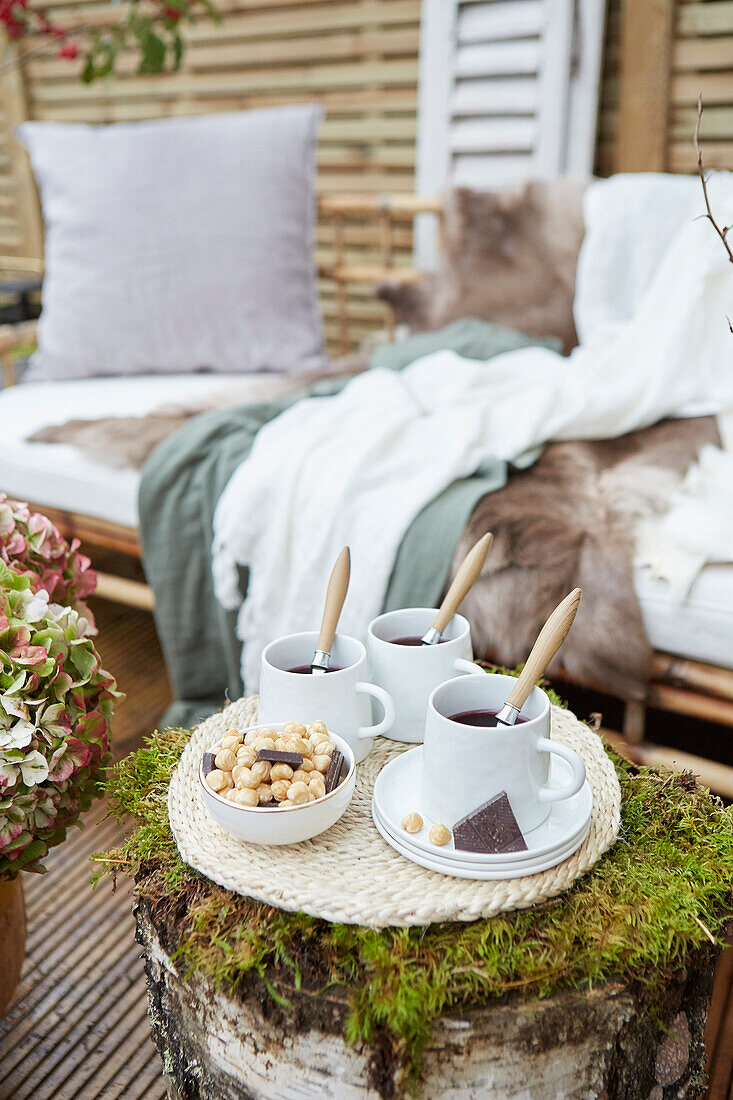 Herbstliche Teezeit auf der Terrasse mit rustikalem Holztisch