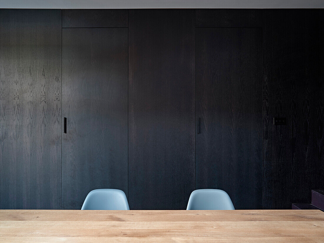 Minimalistisches Design mit schwarzem Holzschrank und hellem Esstisch
