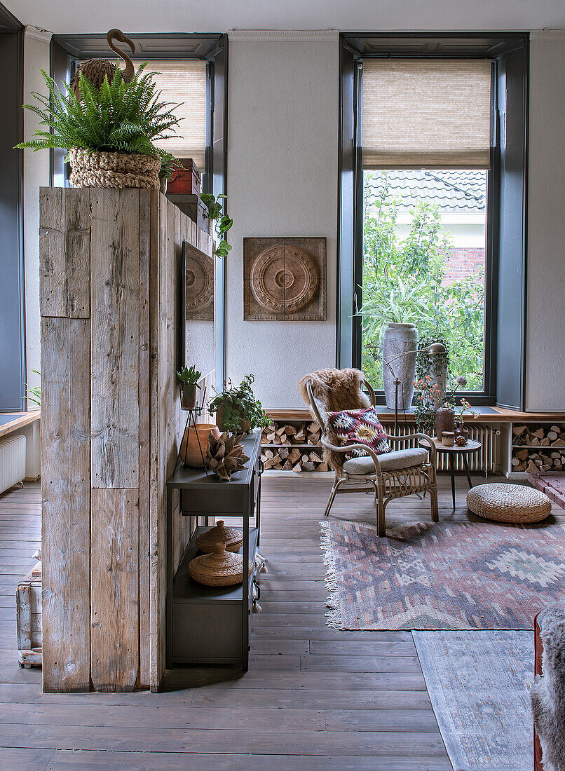 Living area with wooden room divider, rattan armchair and patterned rug