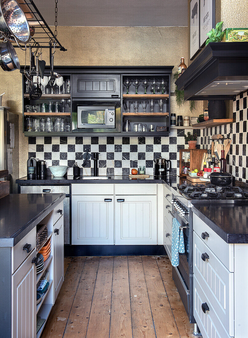 Small kitchen with black and white chequered tiles and wooden floorboards