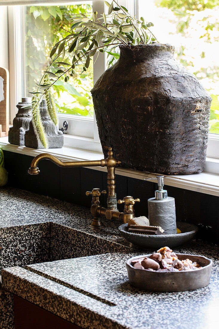 Kitchen sink and counter with granite surface and rustic decor