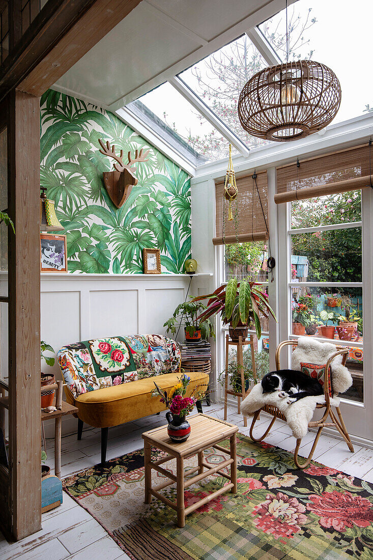 Conservatory with skylight, plant wallpaper and rattan armchair