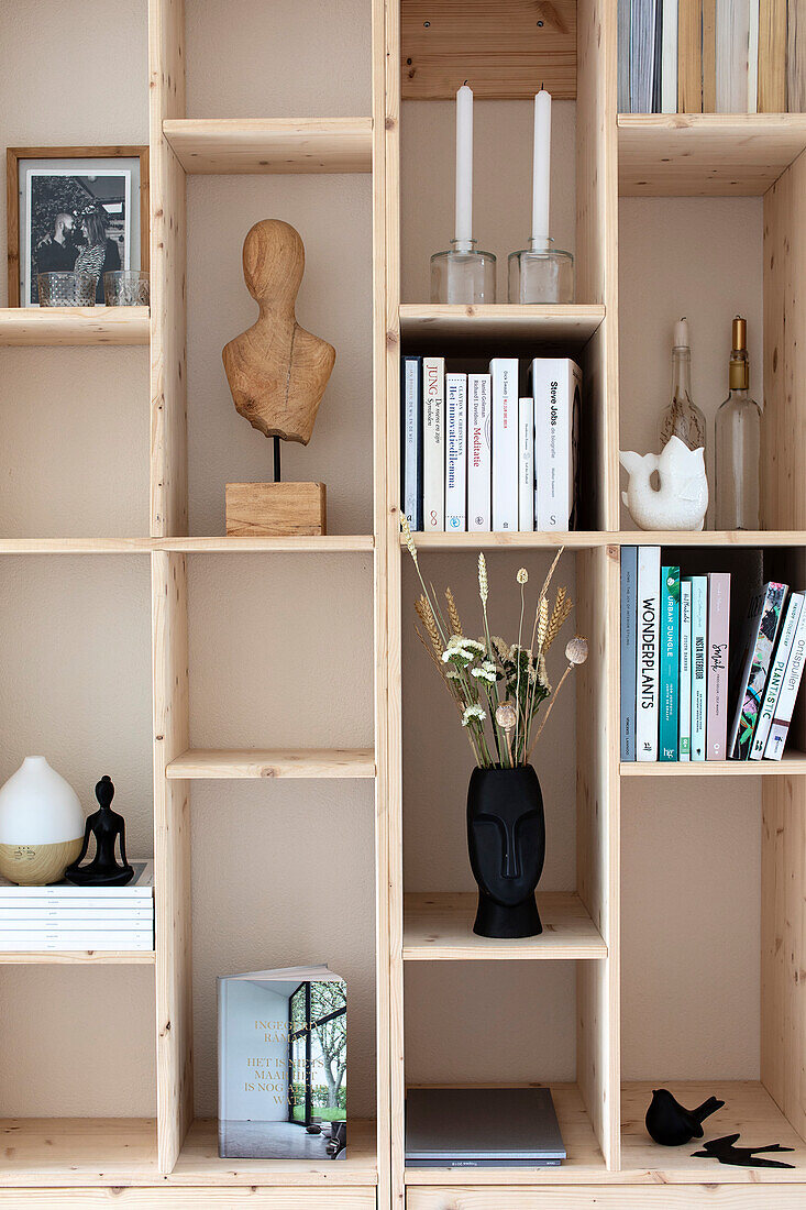 Wooden shelf with decorative objects, books and candlesticks