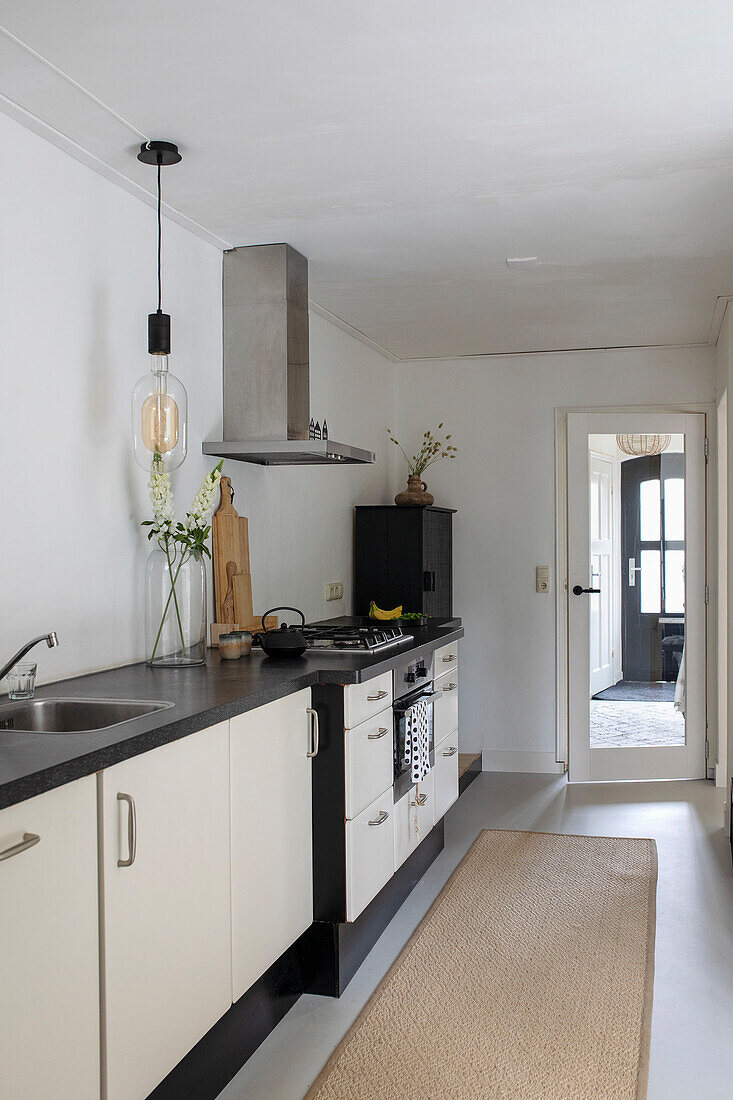 Modern fitted kitchen with white fronts and black worktop