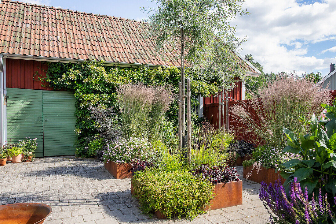 Modern designed patio with grasses and Corten steel raised beds