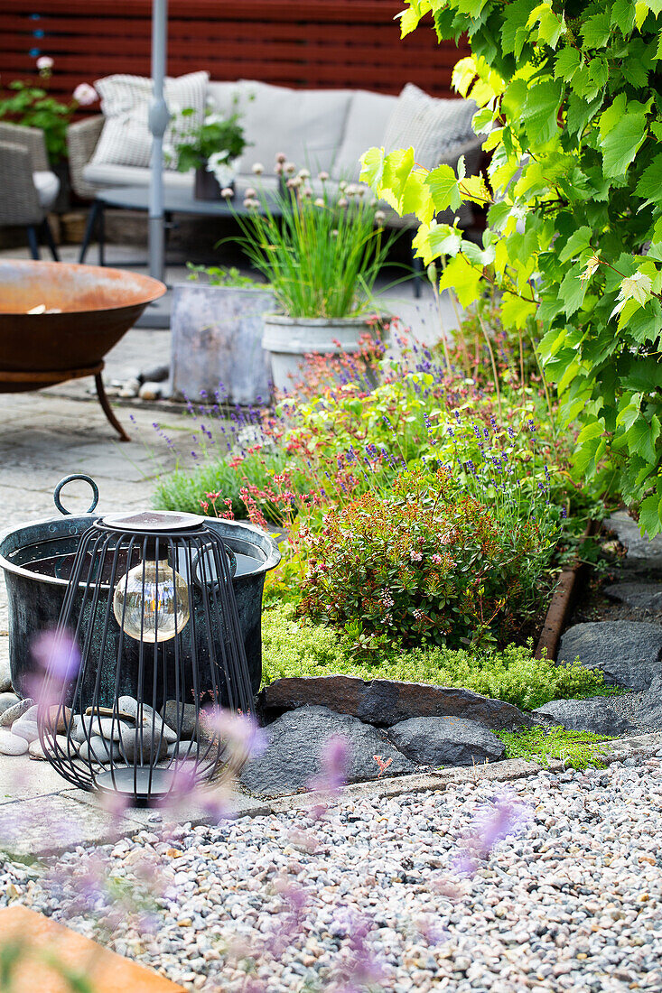 Gemütlich Terrasse mit Feuerstelle, Wasserkübel und Laterne