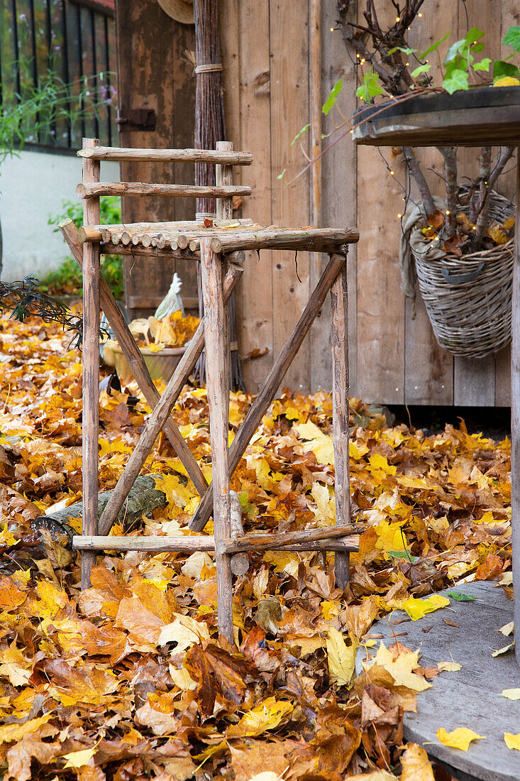 DIY bar stool surrounded by autumn leaves