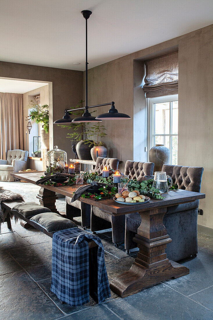 Dark wood dining table with candles and plant arrangement in the rustic dining room