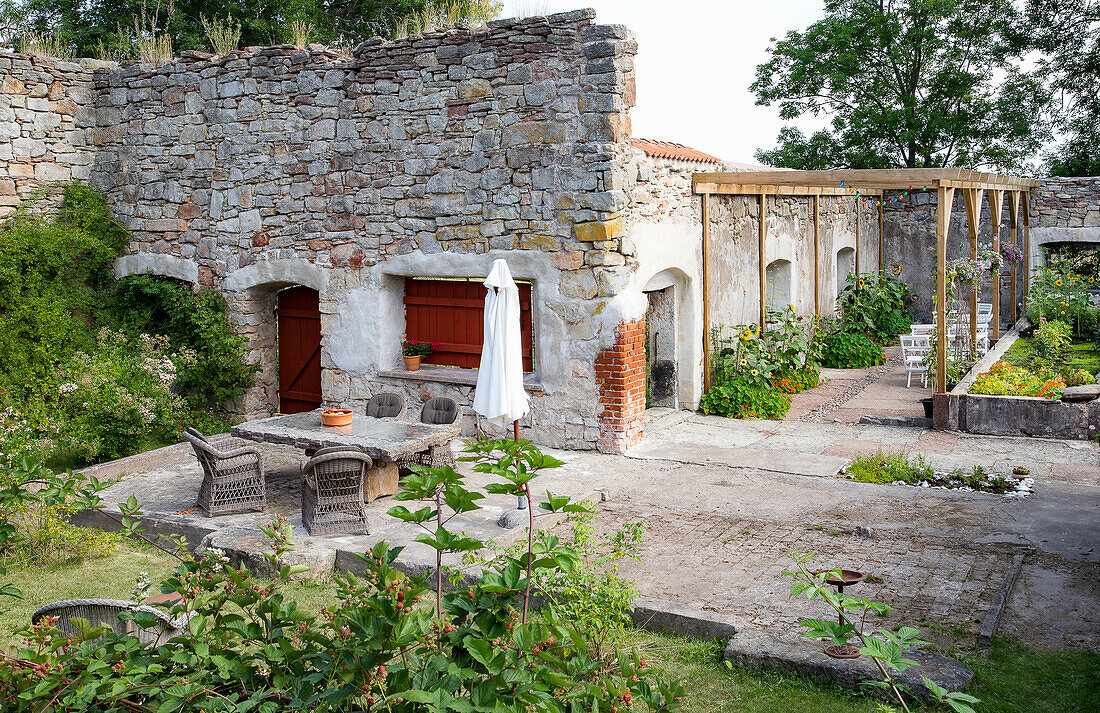 Garden in front of stone building with several seating areas