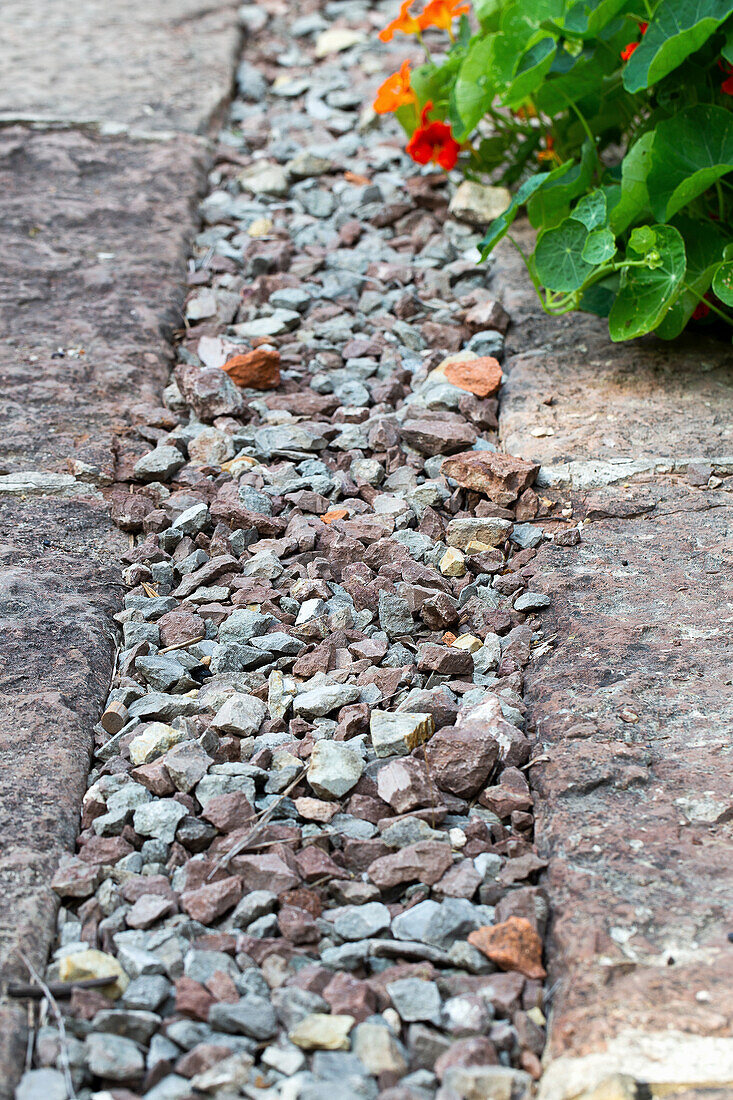 Narrow gravel strip between natural stone slabs