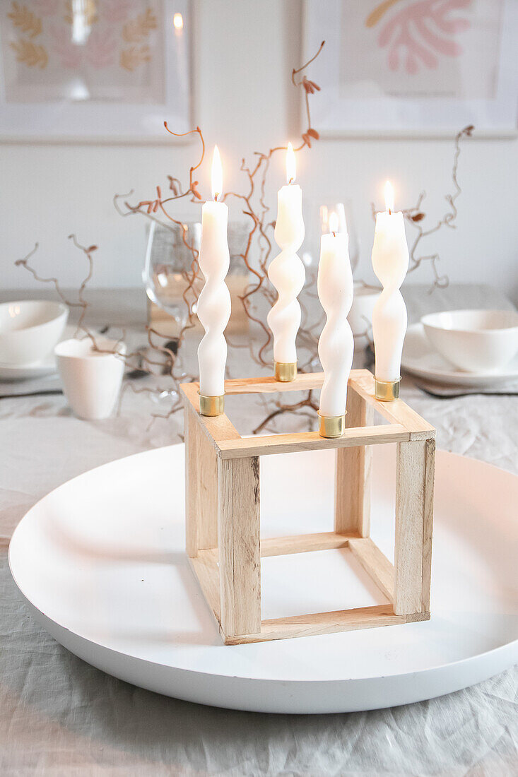 Wooden candle holder with twisted candles on a table setting