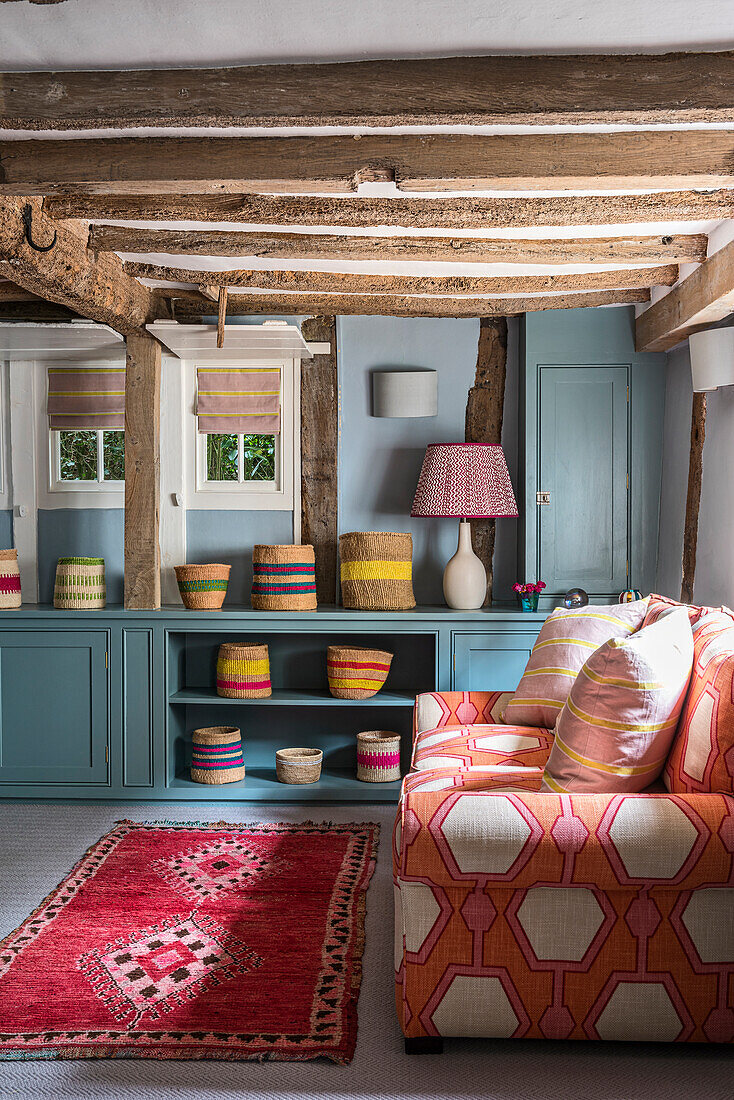 Country-style living room with exposed wooden beams and colorful textiles