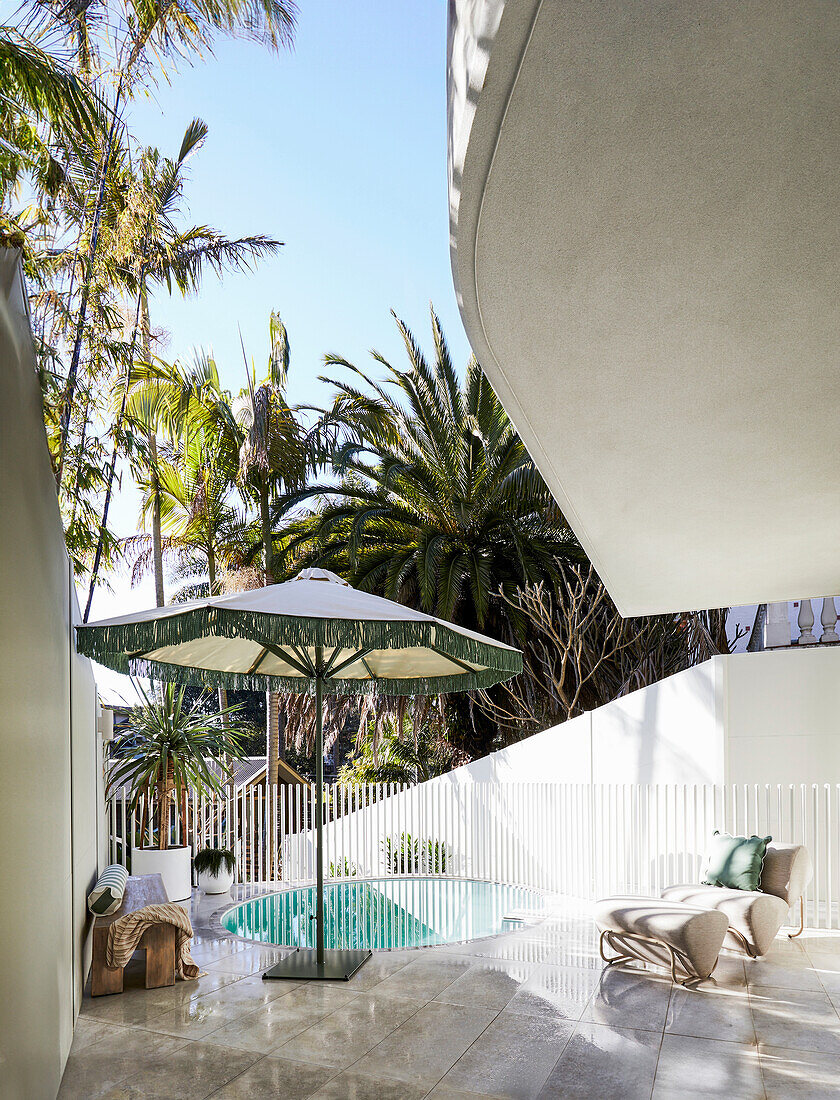 Modern patio with pool, parasol and lounge chair