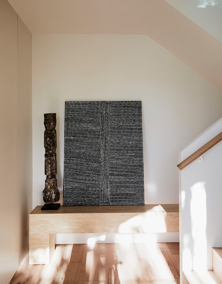 Wooden bench in the hallway with modern art and sculpture