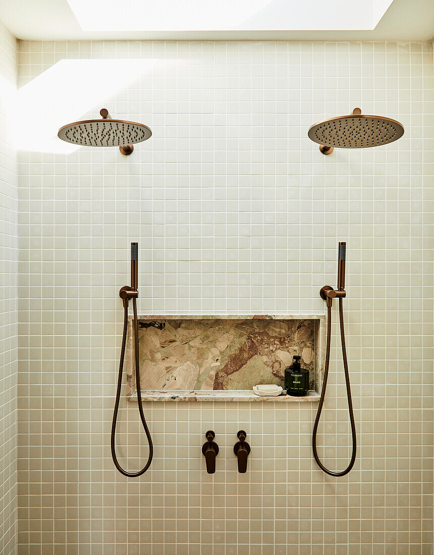 Double shower with rain shower heads and integrated marble shelf