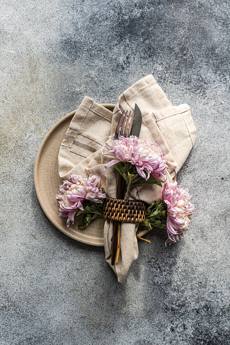 Rustikale Tischdekoration mit Chrysanthemen und Leinenserviette