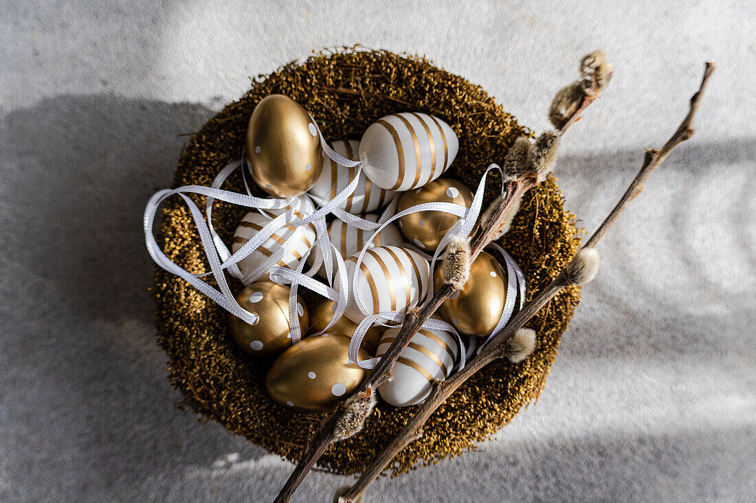 Bird best with colored golden and white eggs as a Easter card