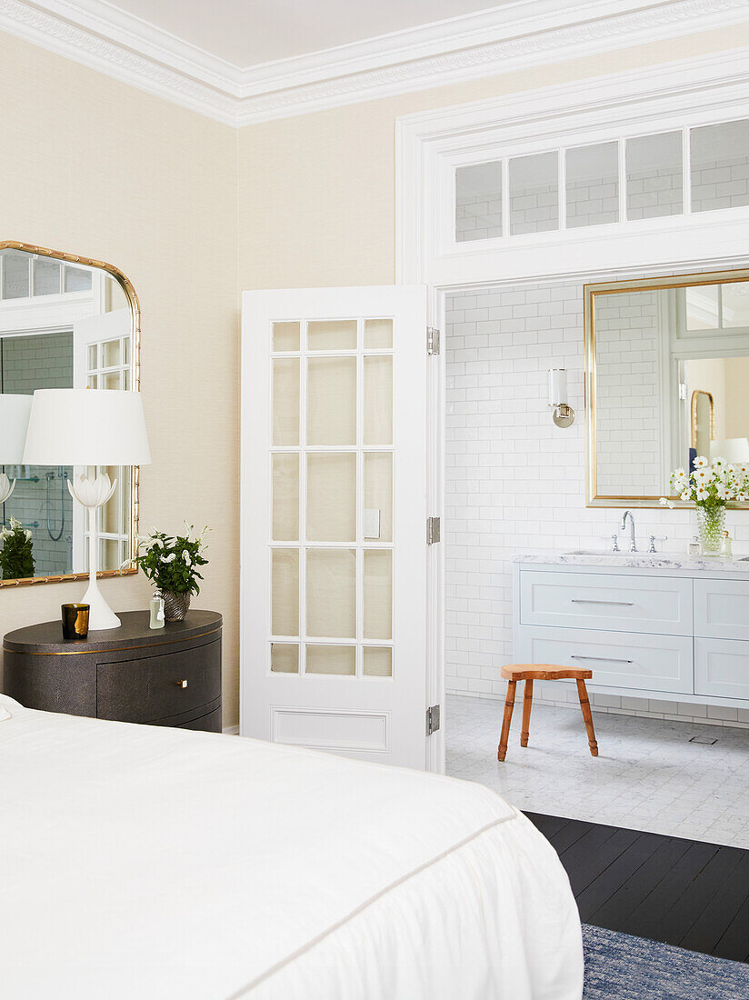 Bedroom with see-through door to white bathroom