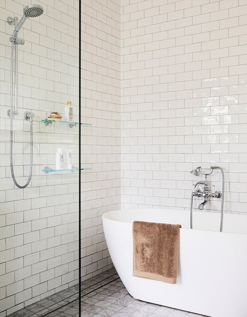 Freestanding bathtub and glass shower with white metro tiles