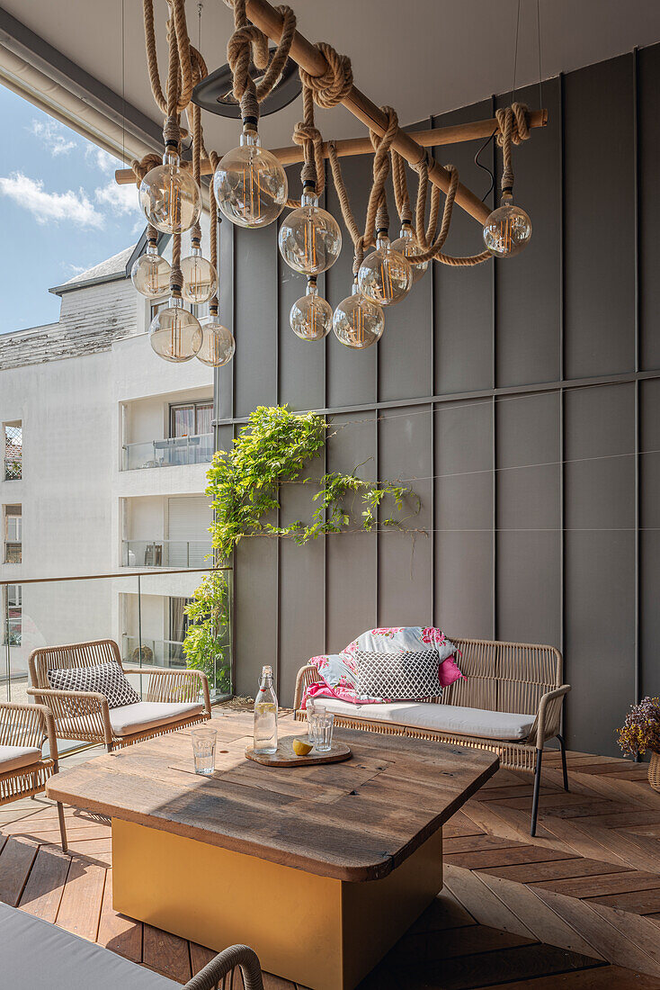 Großer Balkon mit Holzboden und Hängeleuchte