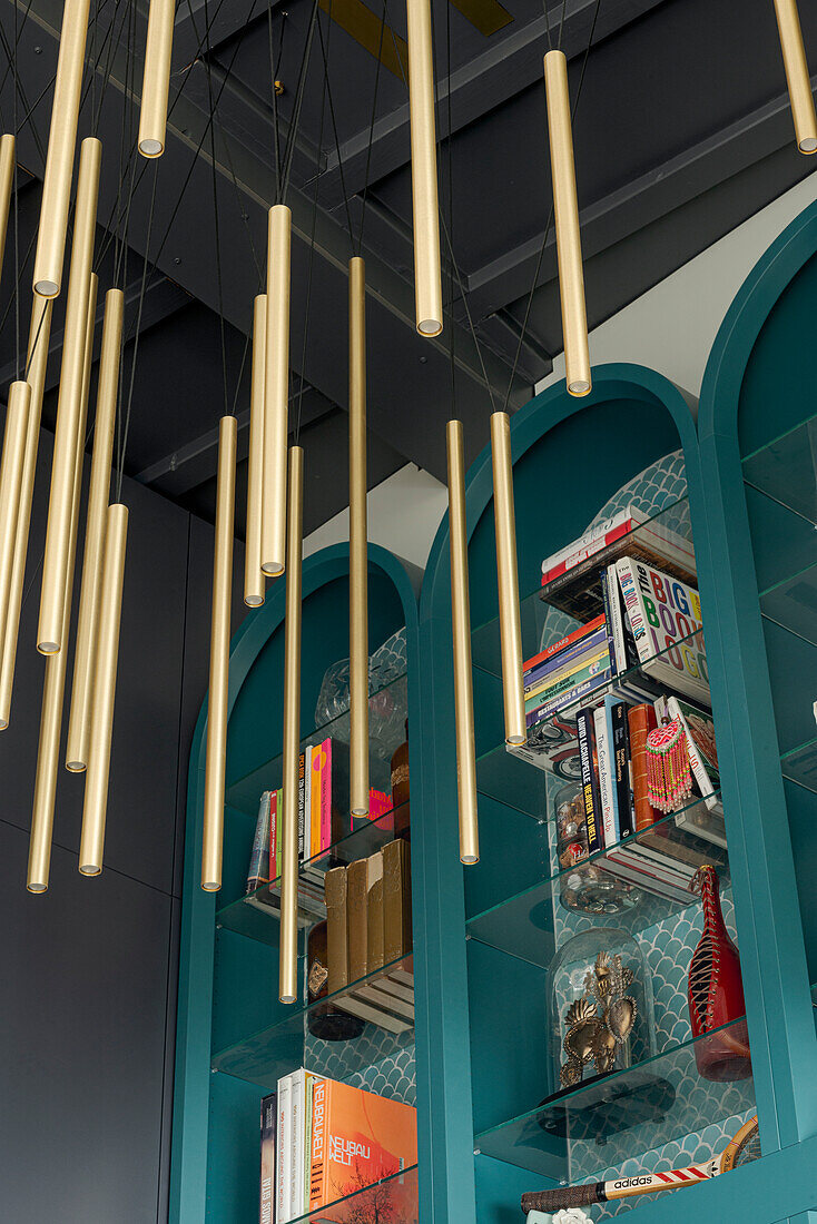 Modern bookcase, golden hanging lamps and decorative elements