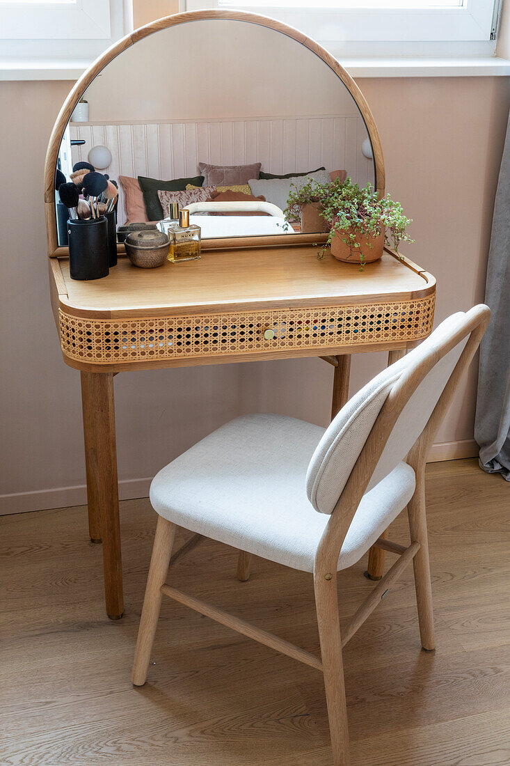 Schminktisch mit gebogenem Spiegel und Rattandetails im Schlafzimmer