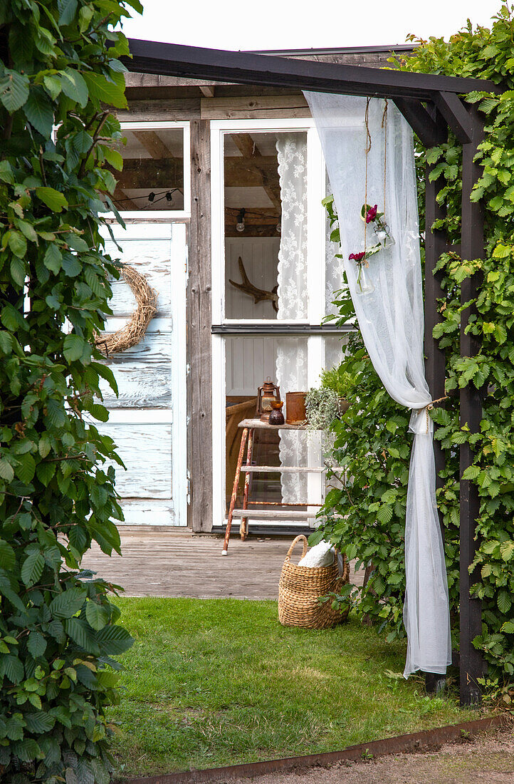 Gazebo with climbing plants and wooden decor