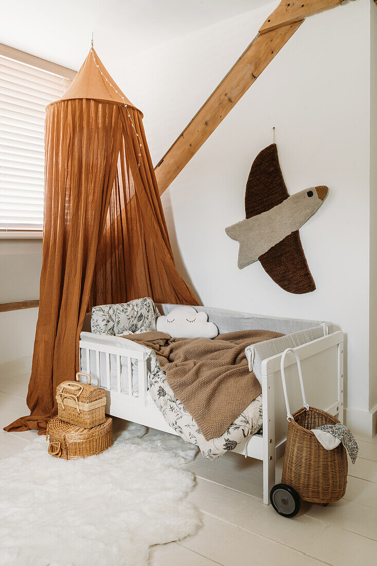 Baby cot with canopy and wall decoration in the shape of a bird