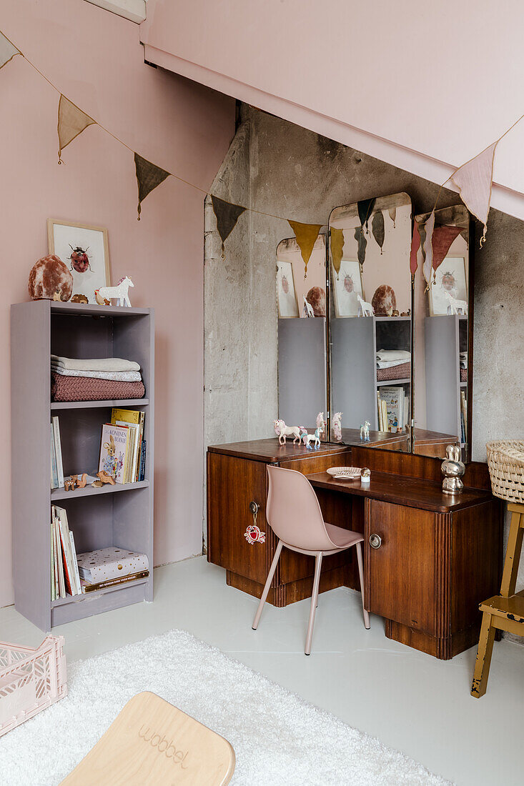 Desk and shelf in children's room with pennant garland and pink walls