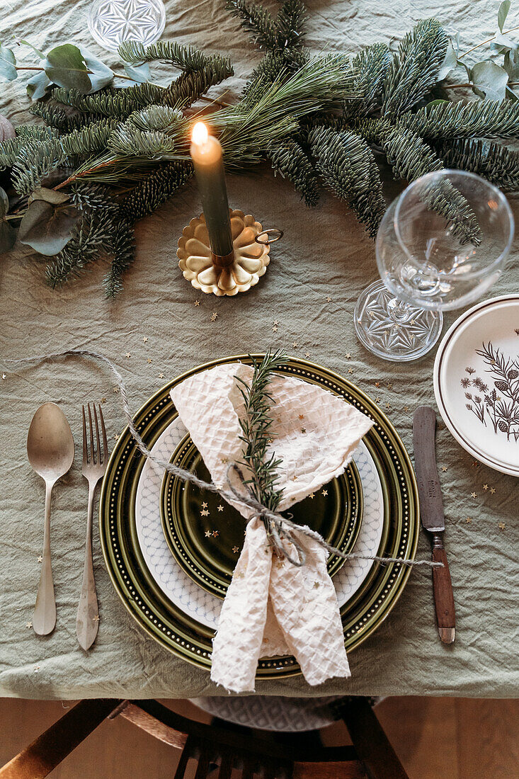 Christmas table setting with candles and fir branches