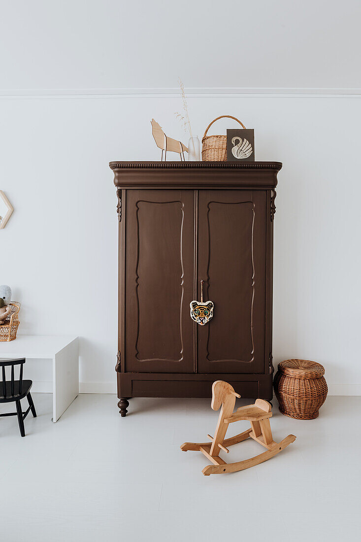 Antique dark brown cupboard in living room with rocking horse and play corner