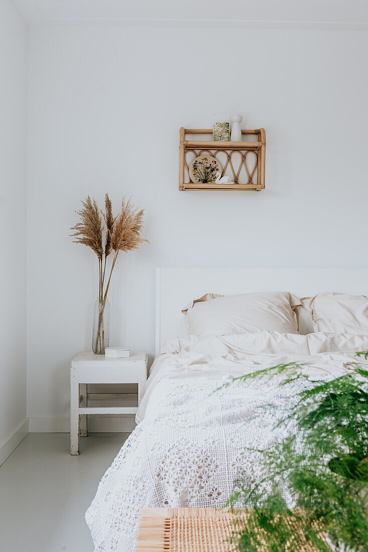 Bedroom with rattan wall shelf and boho decorations