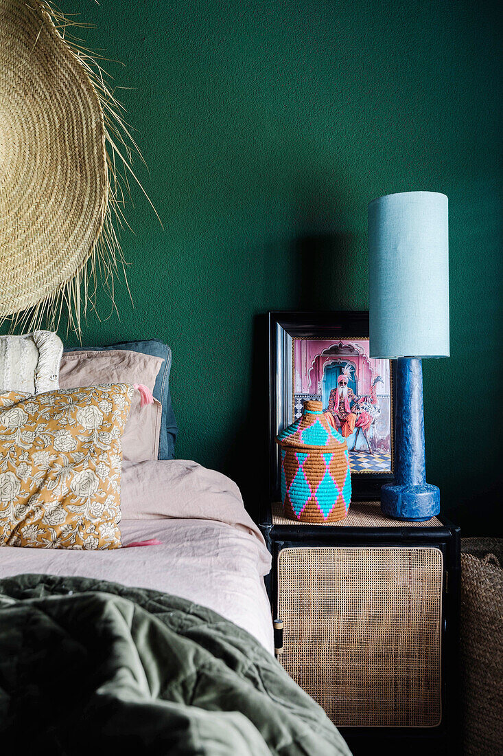 Bedroom with green wall, bed and decorated bedside table